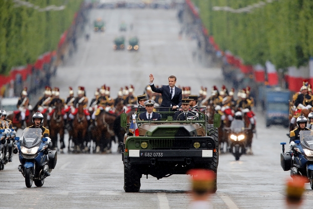 Le président Emmanuel Macron à bord d'un véhicule militaire remonte l'avenue des Champs-Elysées lors de sa journée d'investiture, le 14 mai 2017 à Paris
