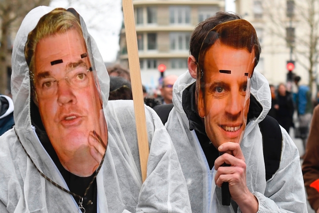 Des manifestants portant des masques représentant Jean-Paul Delevoye pour l'un et Emmanuel Macron pour l'autre, le 10 décembre 2019, lors d'une manifestation contre la réforme des retraites