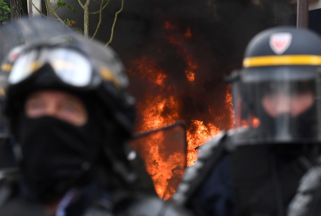 Des CRS devant un incendie en marge de la manifestation du 1er Mai à Paris