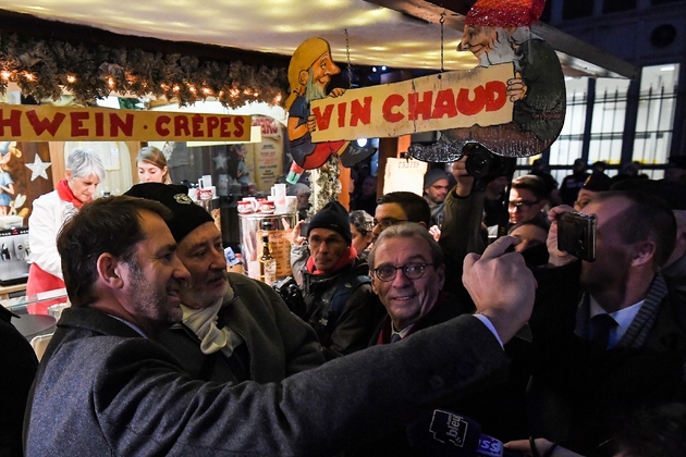 Le ministre de l'Intérieur Christophe Castaner (G) fait un selfie au marché de Noël de Strasbourg, le 22 novembre 2019