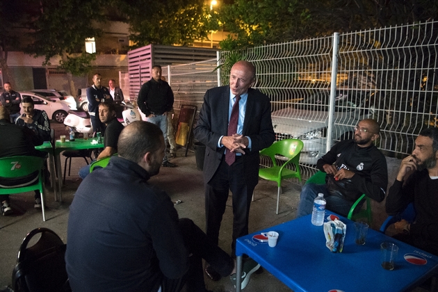 Le ministre de l'Intérieur, Gérard Collomb (c) parle avec des habitants de la cité de la Busserine, le 24 mai 2018 à Marseille