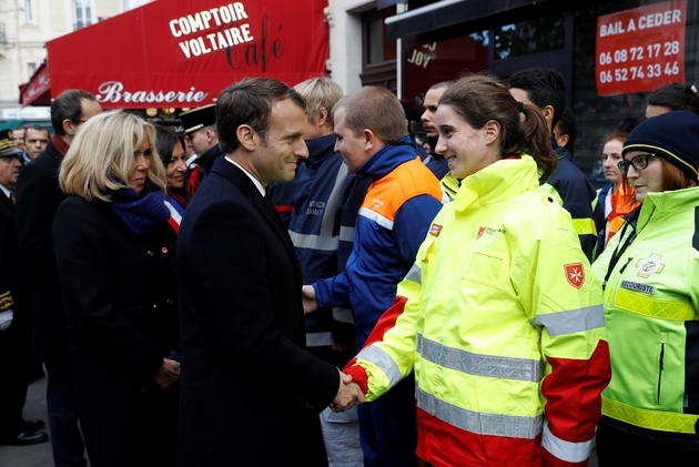 Le président Emmanuel Macron et sa femme Brigitte saluent des secouristes devant le bar Le Comptoir Voltaire pendant une cérémonie marquant le 2e anniversaire des attentats de Paris le 13 septembre 2017
