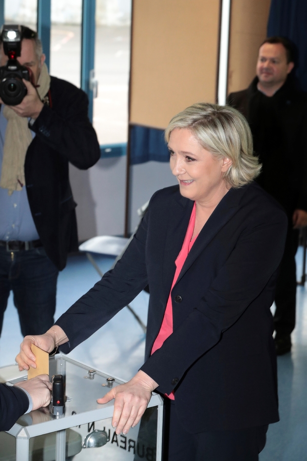 Marine Le Pen glisse son bulletin dans l'urne du bureau de vote de Hénin-Beaumont, lors du deuxième tour de la présidentielle qui l'oppose à Emmanuel Macron, le 7 mai 2017